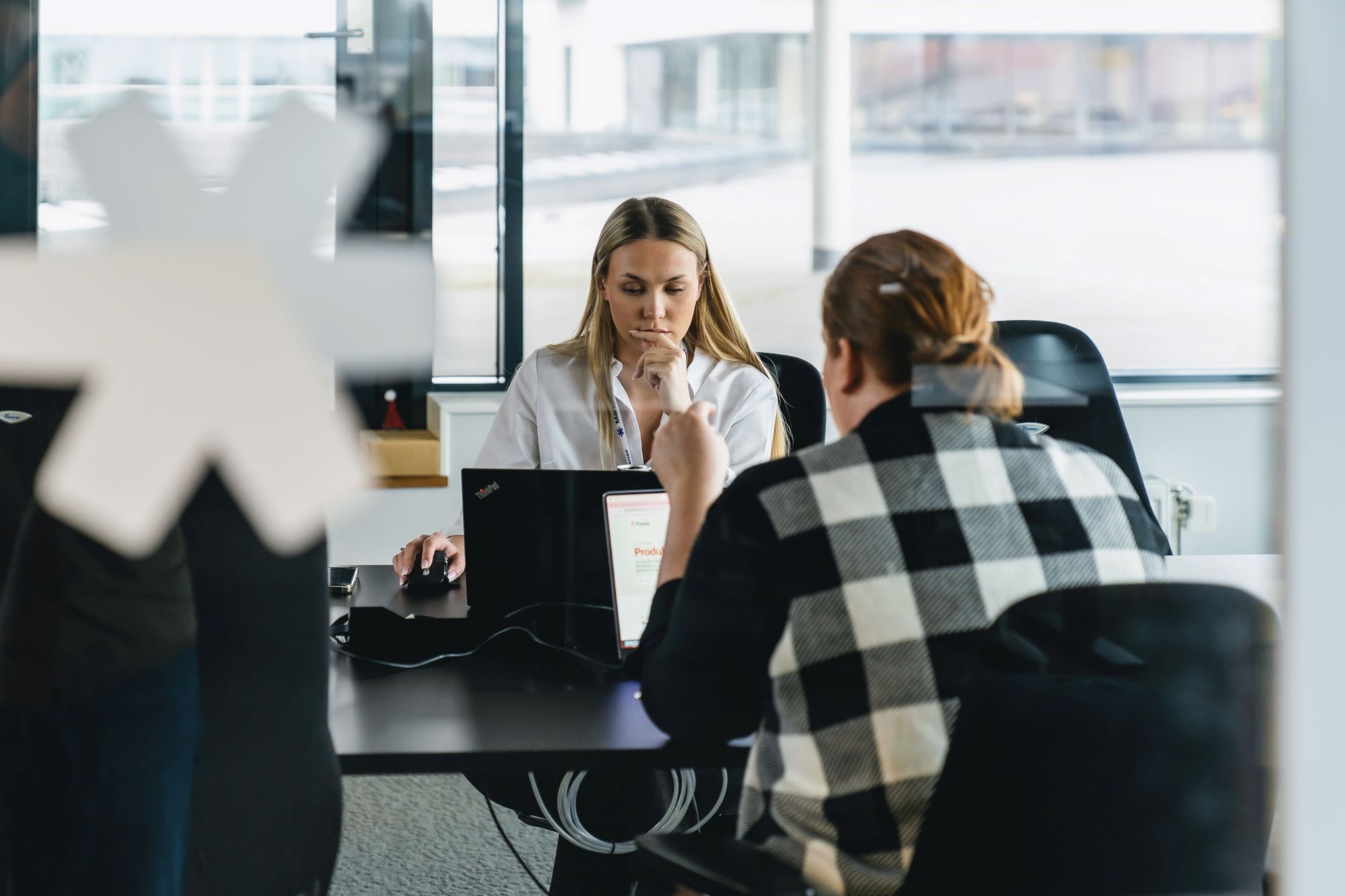 To Intuvio-ansatte som sitter i stoler