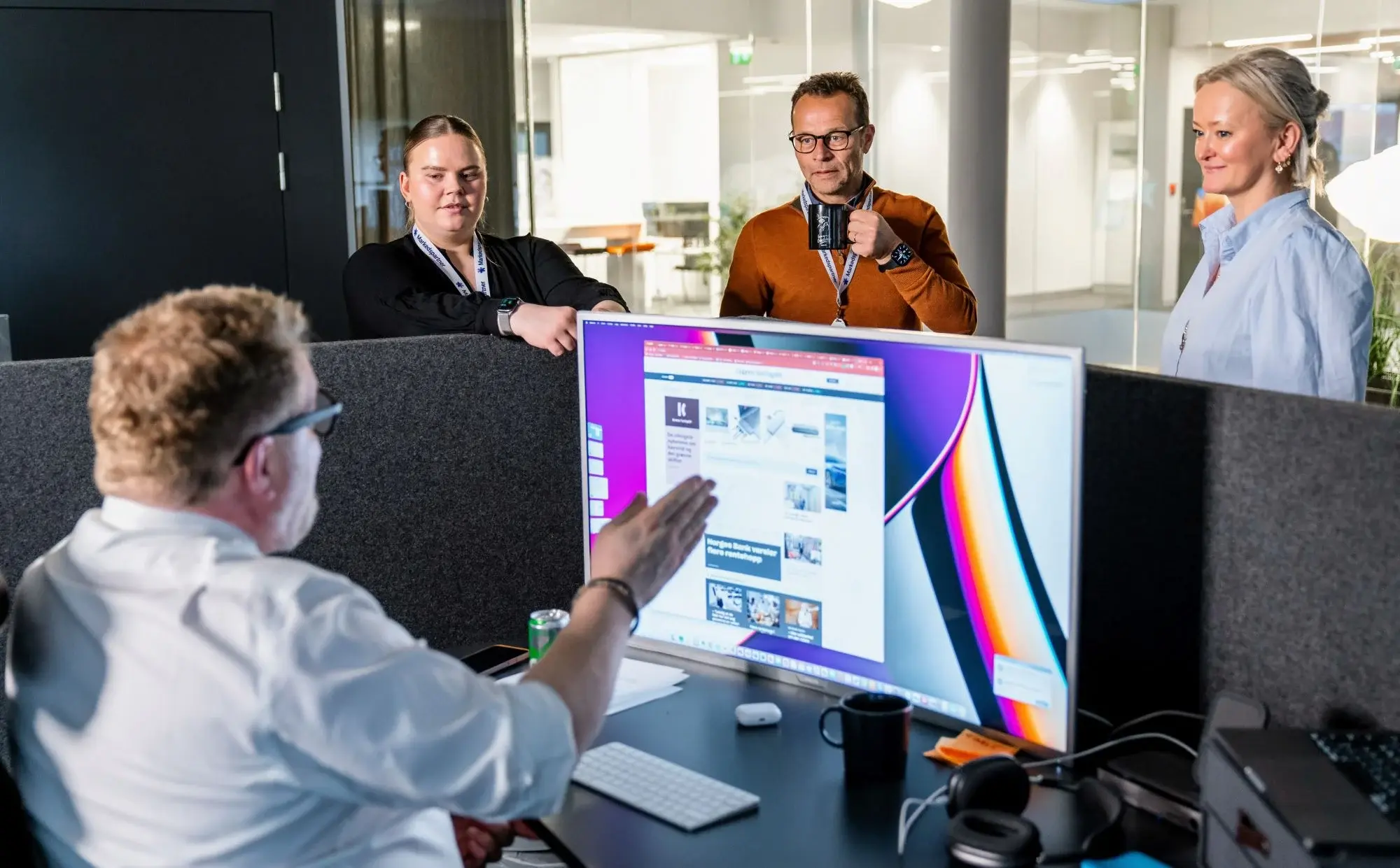 Ansatte viser på en skjerm 
